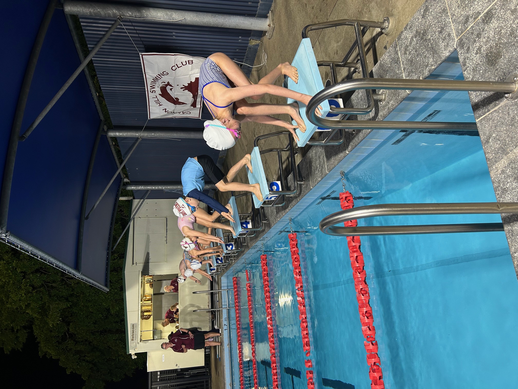 Swimmers diving into the pool at race start